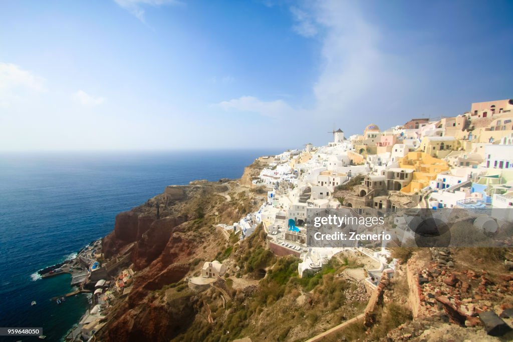 A blue and white Oia village with a windmill at the cliff look out to Aegean sea on Santorini island, Mediterranean, Greece