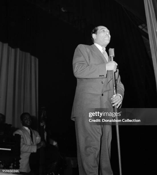 Portrait of Duke Ellington performing onstage with Junior Raglin at the Howard Theater in Washington DC.