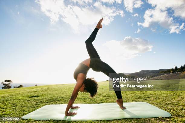 woman doing yoga in green field - acroyoga stock pictures, royalty-free photos & images