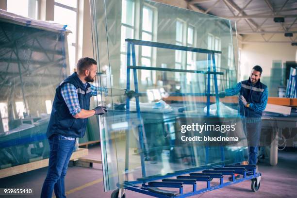 arbeitnehmer, die verpackung glasscheiben im lager - glass factory stock-fotos und bilder