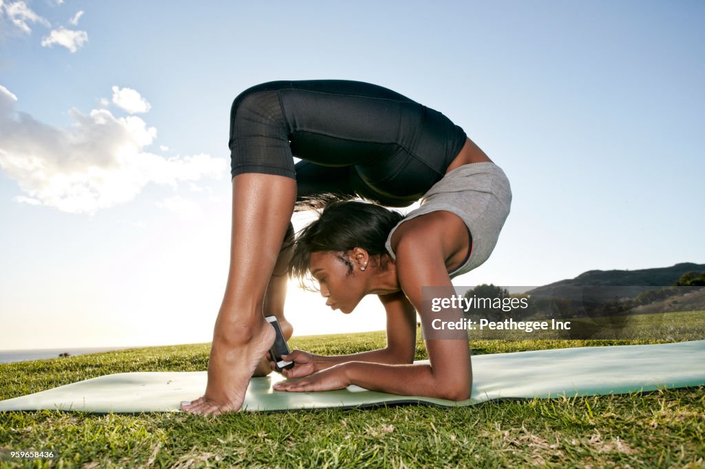 Woman doing yoga in green field