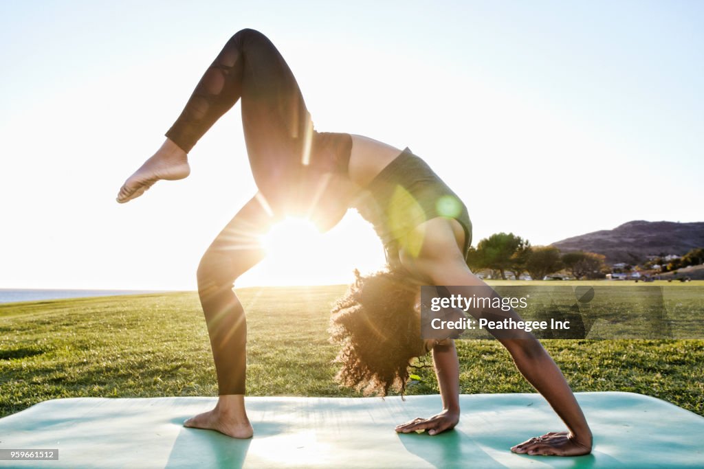 Woman doing yoga in green field