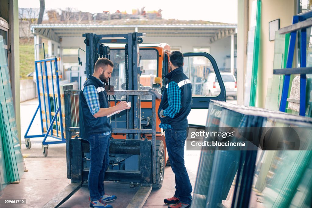 Workers in warehouse with forklift