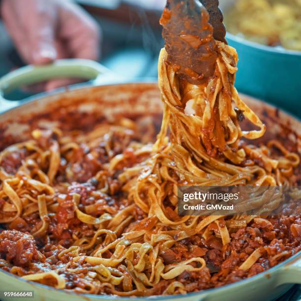 preparación de pasta de tallarines con boloñesa vegana y bella lodi queso - salsa boloñesa fotografías e imágenes de stock
