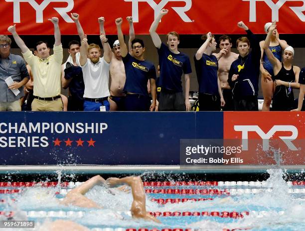Members of the Michigan University swim team cheer on Felix Auboeck during the men's 400 meter freestyle final during the TYR Pro Swim Series at...