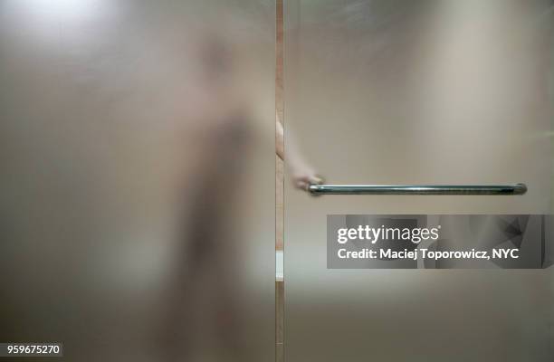 view of a naked person through a frosty glass in the bathroom. - flasher stock-fotos und bilder