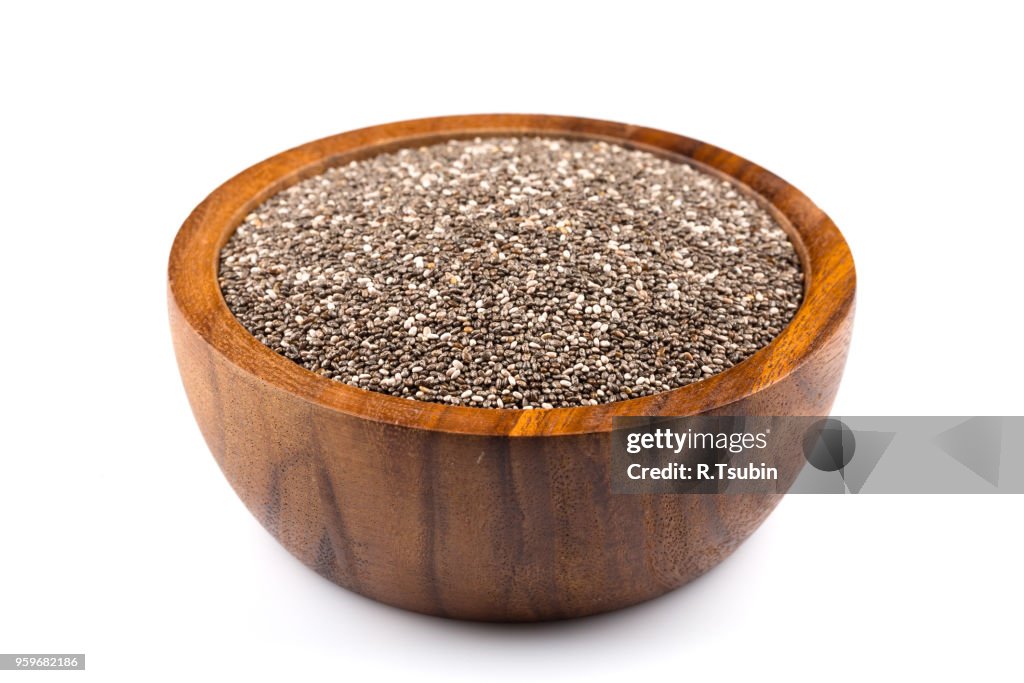 Chia seeds in wooden bowl on white background
