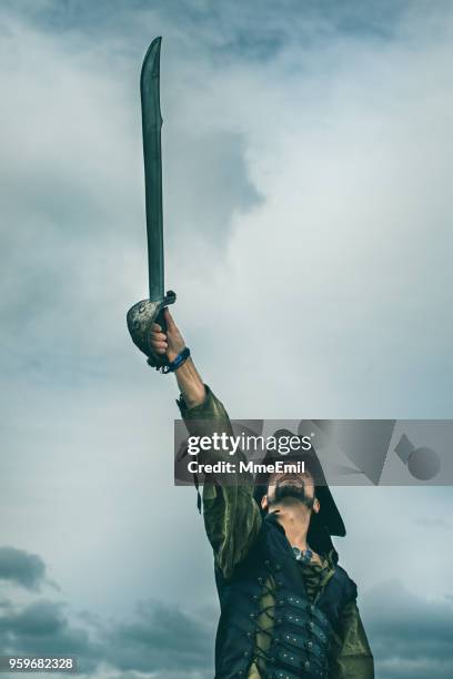 pirate holding a sword in a storm - kids sailor costume stock pictures, royalty-free photos & images