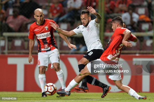 Brazil's Corinthians midfielder Maycon controls the ball between Venezuela's Deportivo Lara defender Ignacio Anzola and defender Daniel Carrilo...