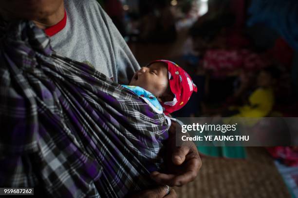 In this picture taken on May 11 an internally displaced woman with a baby are seen at a temporary shelter at a church compound in Tanghpre village...