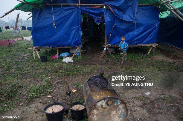 In this picture taken on May 12 an internally displaced child looks on outside temporary shelter in Danai, Kachin state. - Often called the...