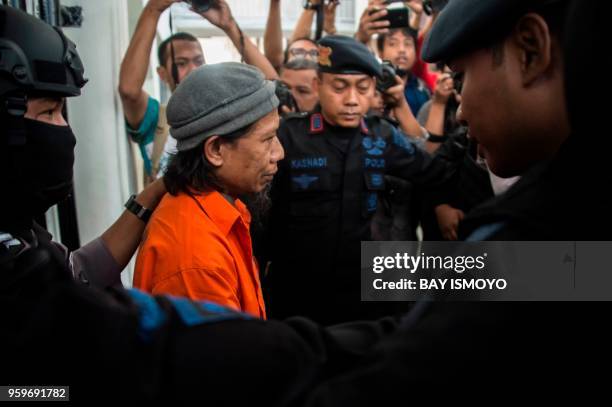 Armed police escort Aman Abdurrahman, leader of the Islamic State group -linked militant outfit Jamaah Ansharut Daulah, to a court hearing for the...