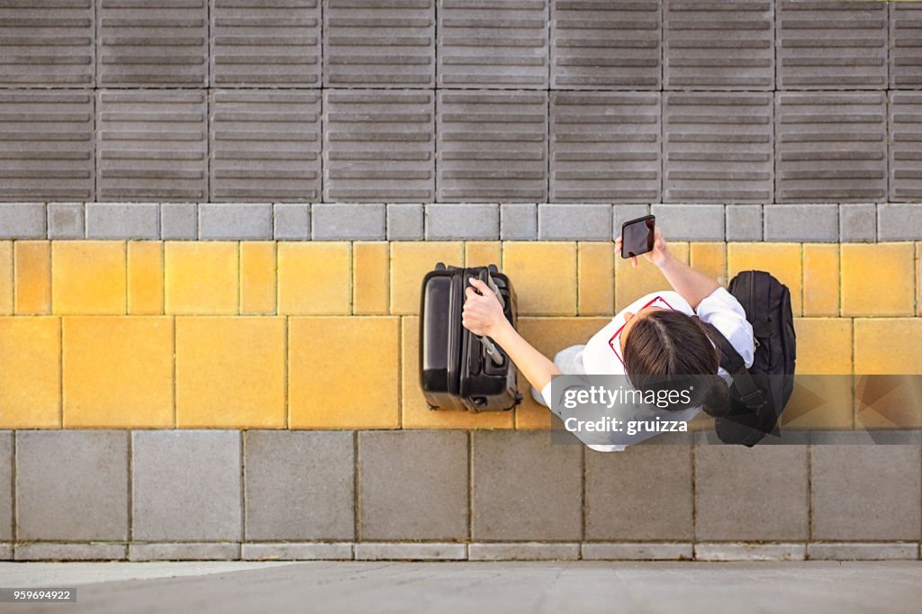 High angle view of a young woman using her smart phone