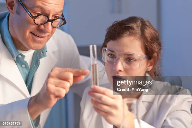 two science reachers teacher and student working together in chemistry laboratory or university class - liquid solution stock pictures, royalty-free photos & images