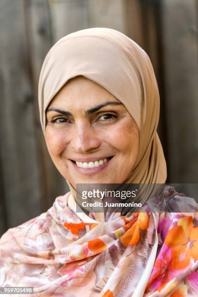 muslim mature woman looking at the camera - syrian refugee stock pictures, royalty-free photos & images
