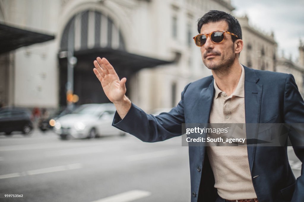 Uomo d'affari che prende il taxi