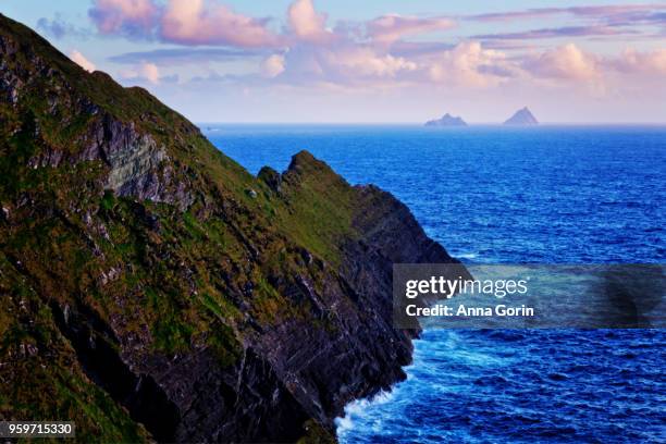 skellig islands on horizon at sunset viewed from kerry cliffs outside portmagee, western ireland - anna gorin stock-fotos und bilder