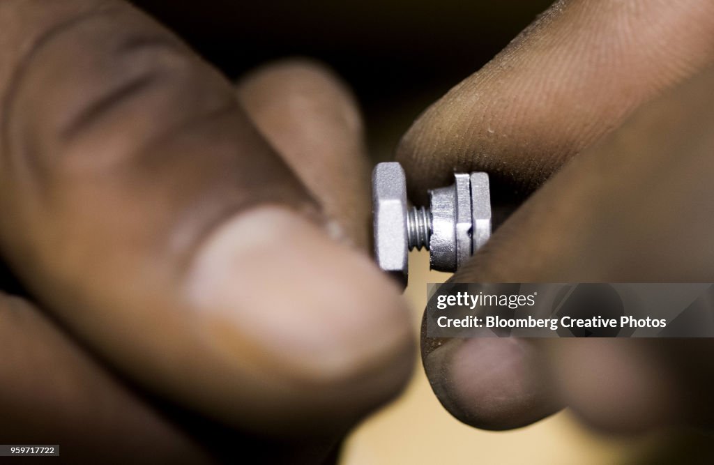 An employee screws small parts together for a bike