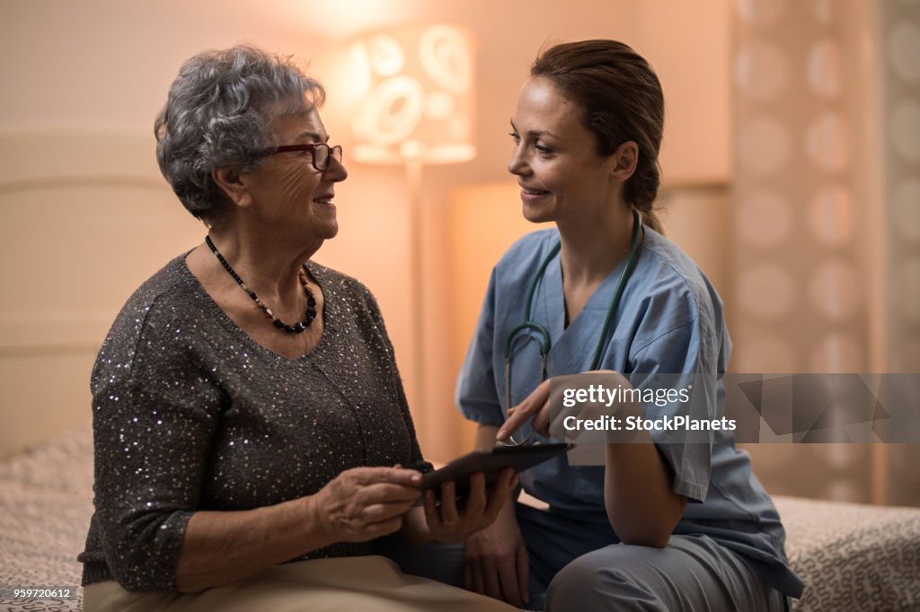 Home caregiver nurse and senior women working together with digital tablet