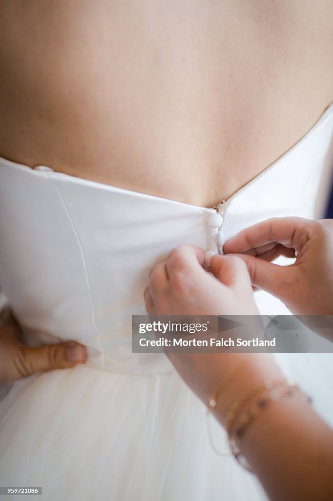 A Bride is Buttoned into her Dress in Berlin, Germany Summertime