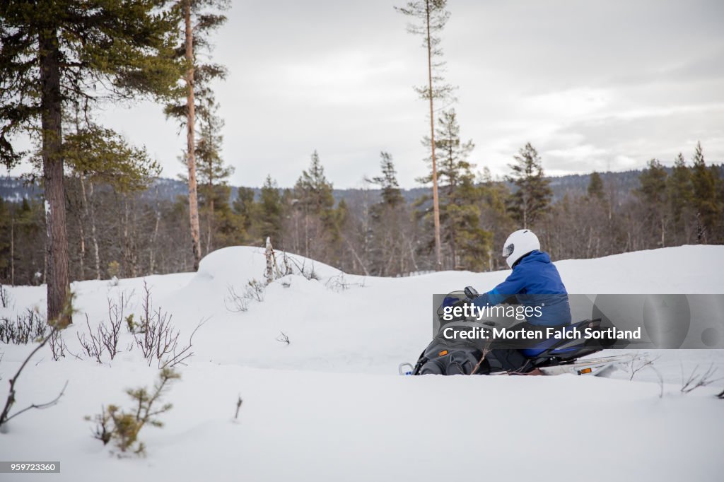 A Man Drives a Snowmobile on a Mountain in Rural Norway, Wintertime