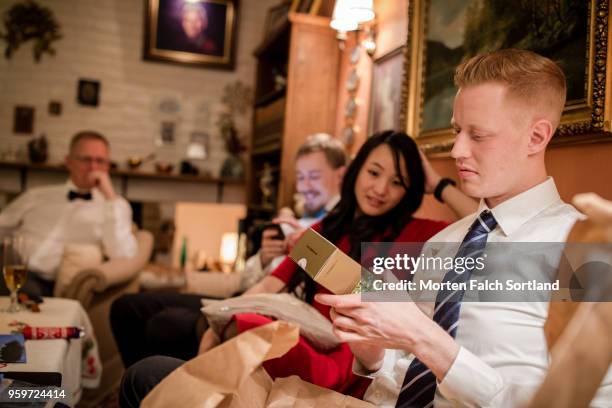 family members exchange gifts during christmas eve celebrations in a home in rural norway - christmas norway stock pictures, royalty-free photos & images