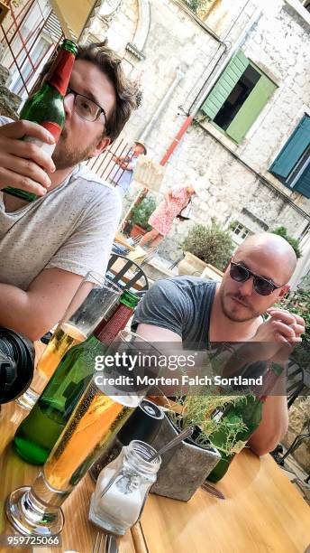 two men drink beer at a restaurant in makarska, croatia autumn-time - makarska imagens e fotografias de stock