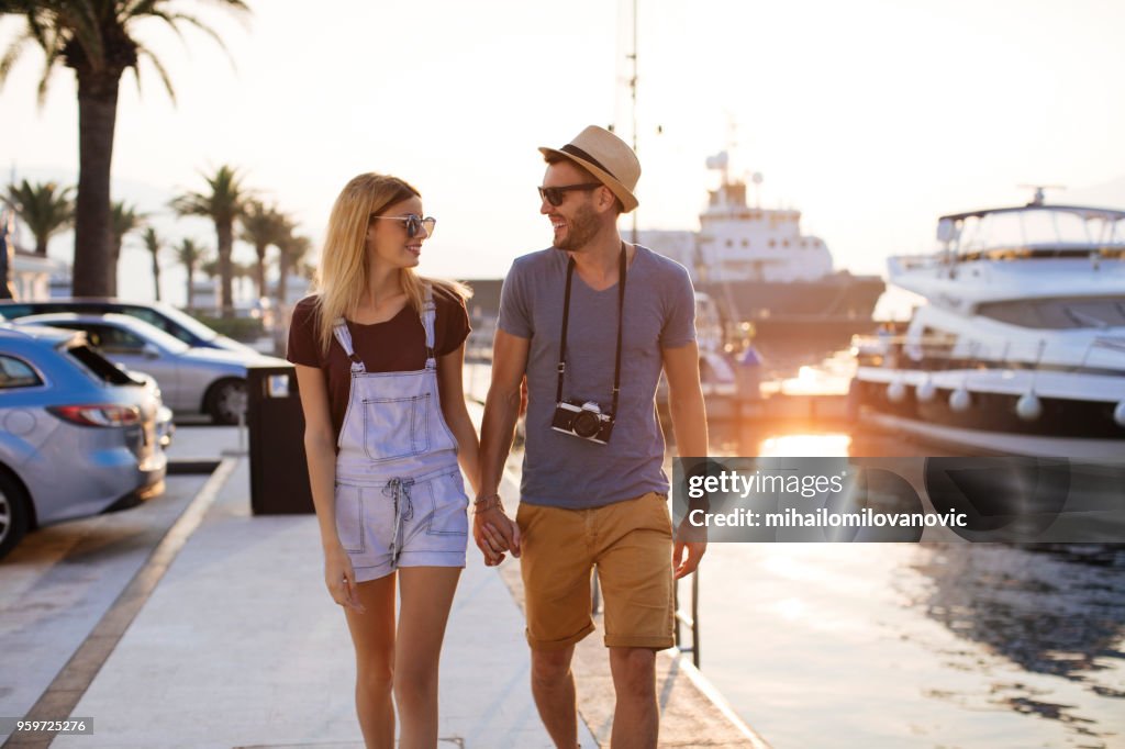 Couple walking along the yacht port at summer