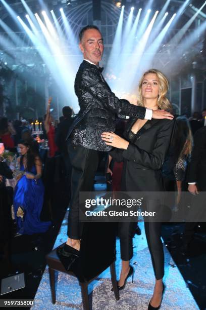 Dan Caten on a chair and Hailey Clauson attend the amfAR Gala Cannes 2018 dinner at Hotel du Cap-Eden-Roc on May 17, 2018 in Cap d'Antibes, France.