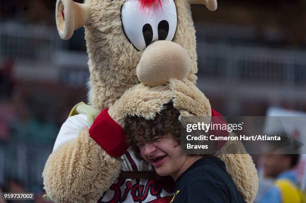 Stranger Things actor Gaten Matarazzo is greeted by Blooper during the game against the San Francisco Giants at SunTrust Park on May 5 in Atlanta,...