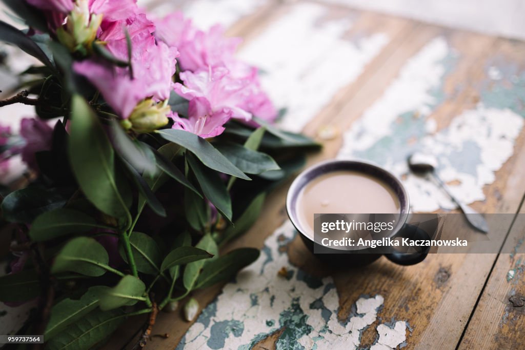 Cup of coffee and pink flowers on the table