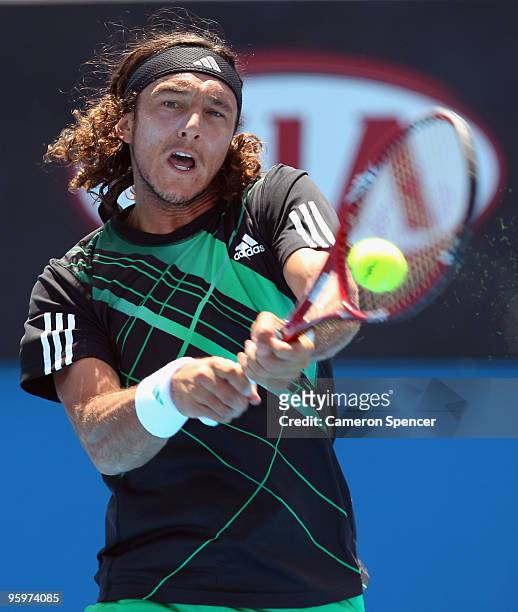 Juan Monaco of Argentina plays a backhand in his third round match against Nikolay Davydenko of Russia during day six of the 2010 Australian Open at...
