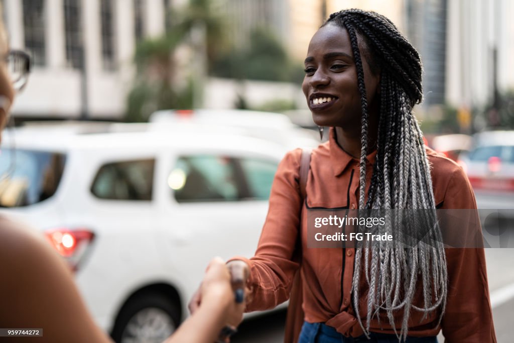 Businesswomen shaking hands in meeting at city