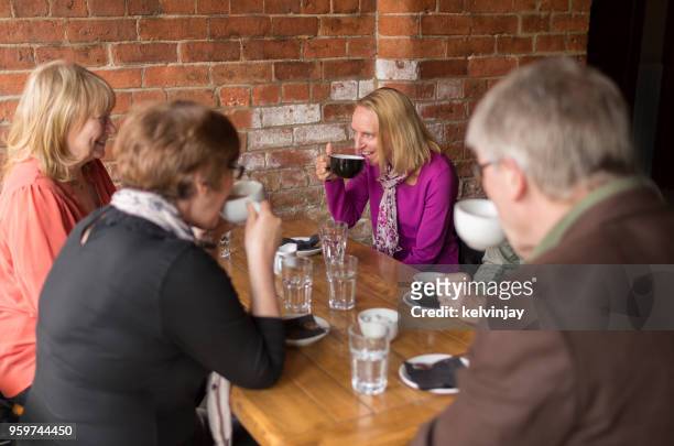 a group of friends drinking coffee in a bar - kelvinjay stock pictures, royalty-free photos & images