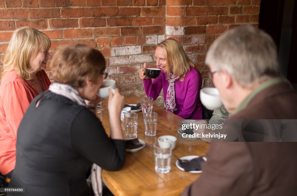 En grupp vänner som dricker kaffe i en bar