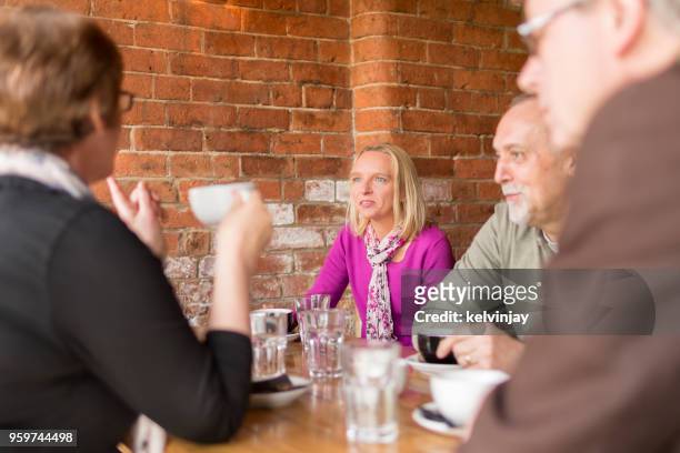 a group of friends drinking coffee in a bar - kelvinjay stock pictures, royalty-free photos & images