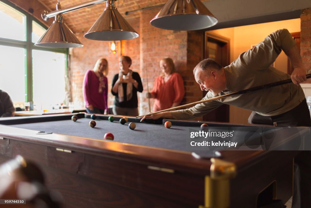 A group of friends playing pool in a bar