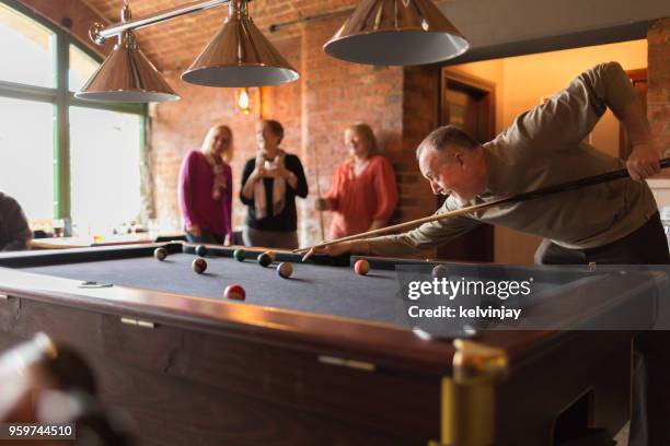 a group of friends playing pool in a bar - playing pool stock pictures, royalty-free photos & images