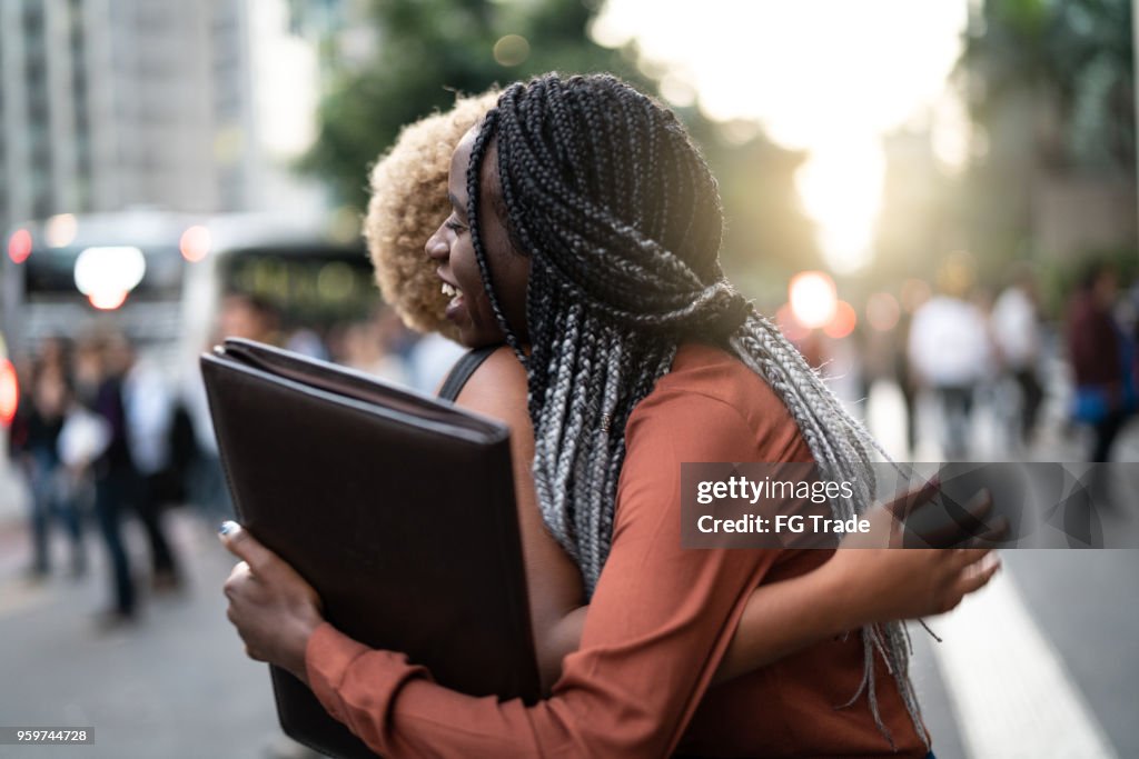 Business woman/students embracing