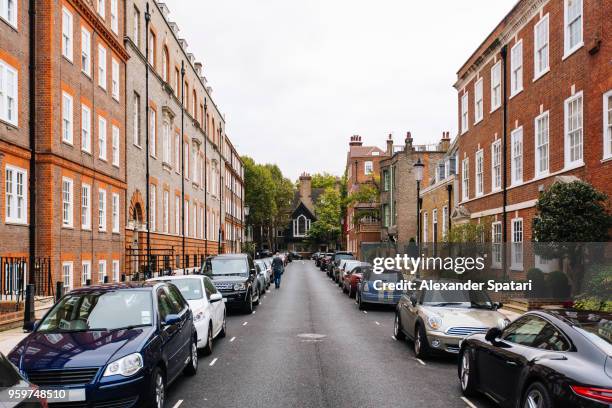 street with parked cars in kensington and chelsea district, london, england, uk - london houses stock-fotos und bilder