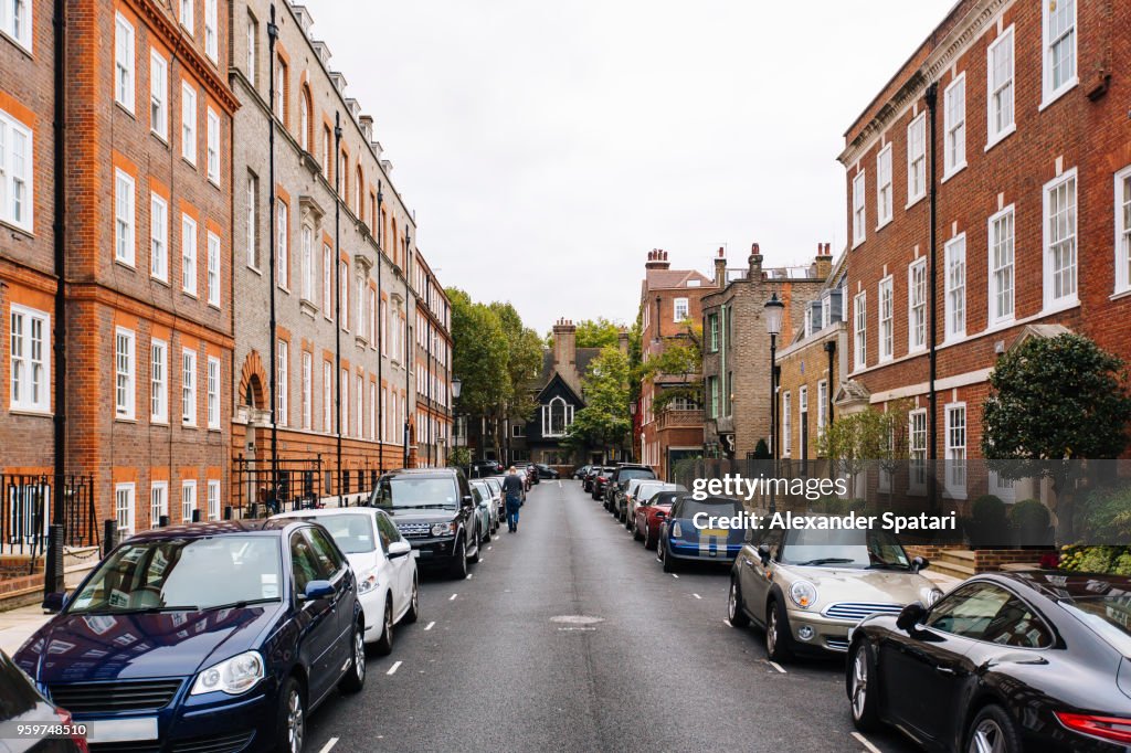 Street with parked cars in Kensington and Chelsea district, London, England, UK