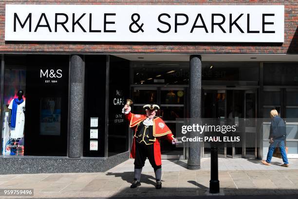 Town cryer rings his bell outside a branch of retailer Marks and Spencer, that has changed the name sign on the facade to Markle and Sparkle in...