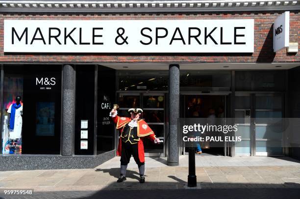 Town cryer rings his bell outside a branch of retailer Marks and Spencer, that has changed the name sign on the facade to Markle and Sparkle in...