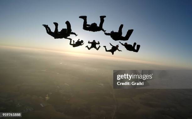 skydiving group at the sunset - fearless records stock pictures, royalty-free photos & images