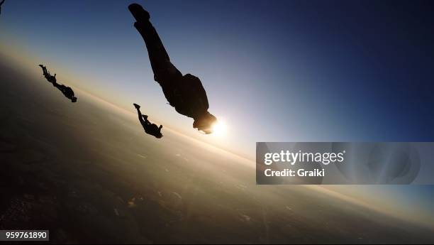 skydiving group at the sunset - parachute jump stockfoto's en -beelden