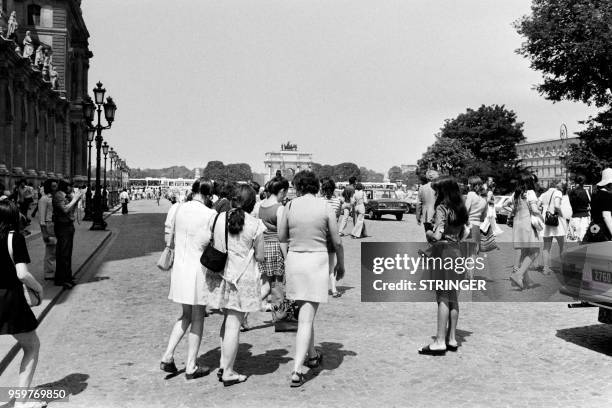 Tourists walk towards the "Arc de triomphe du Carrousel", during a heat period on july 1973, in Paris.