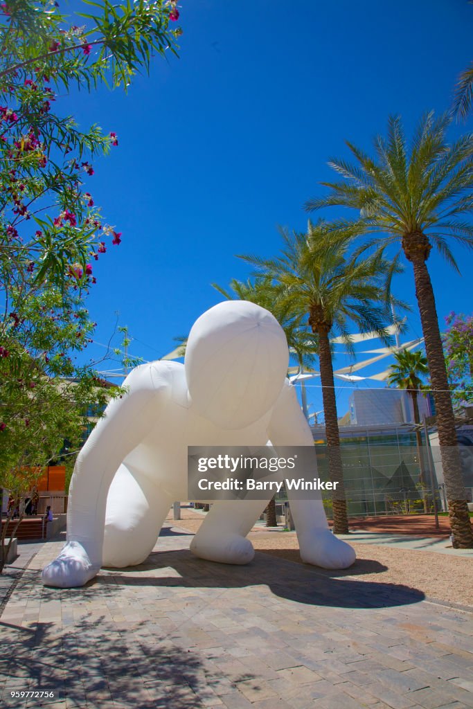 Oversize inflatable balloon in shape of crouching person on street in Mesa, AZ, art, art center, museum, outdoors,