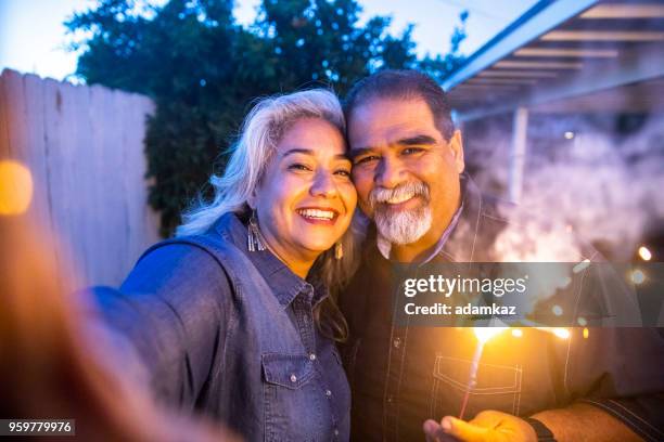 senior couple mexicain tenant le cierge magique tout en prenant un selfie - fat couple photos et images de collection