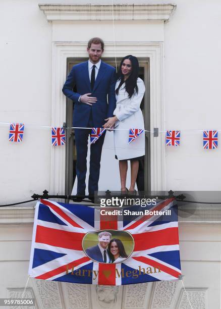 Cardboard cut-out of Prince Harry and Meghan Markle is displayed outside a window ahead of their royal wedding on May 18, 2018 in Windsor, England.