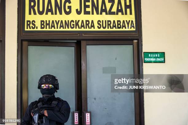 An anti-terror policeman keeps watch amid tight security at a hospital morgue, where the bodies of the individuals involved in the Surabaya suicide...
